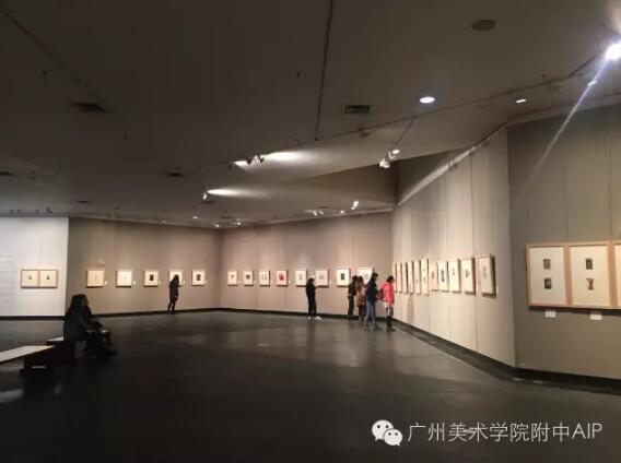 游客在展览厅观看墙壁上摆满了小版画和藏书票